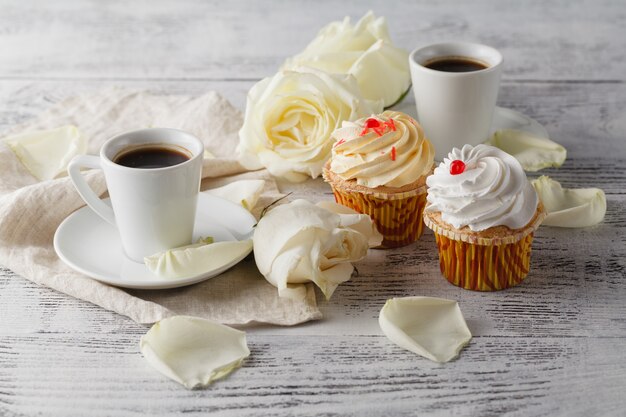 Weiße Rosen und schwarzer Kaffee auf Weiß