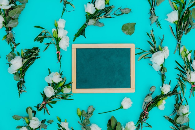 Weiße Rosen und Tafel auf grünem Hintergrund. Ansicht von oben