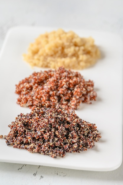Weiße, rote und schwarze gekochte Quinoa auf dem Teller