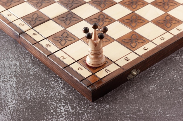 Weiße Schachfigur handgeschnitzt in Holz auf handgefertigtem Brett.Geschäftsstrategie, Taktikkonzept