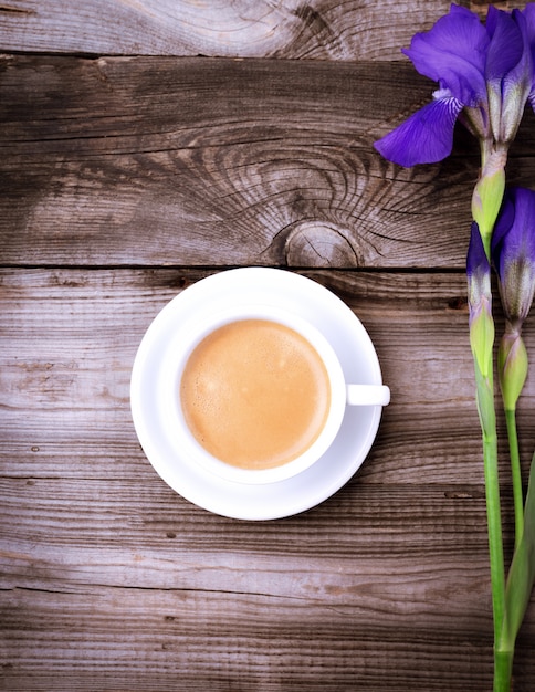 Weiße Schale mit schwarzem Kaffee auf einer grauen Holzoberfläche