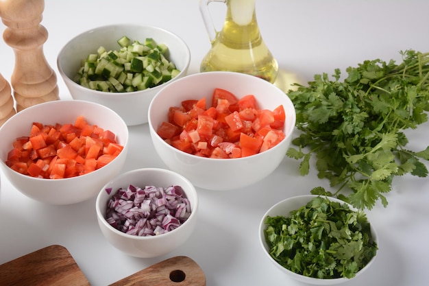 Foto weiße schalen mit geriebenem gemüse in verschiedenen farben kochbrett mit zutaten für den salat