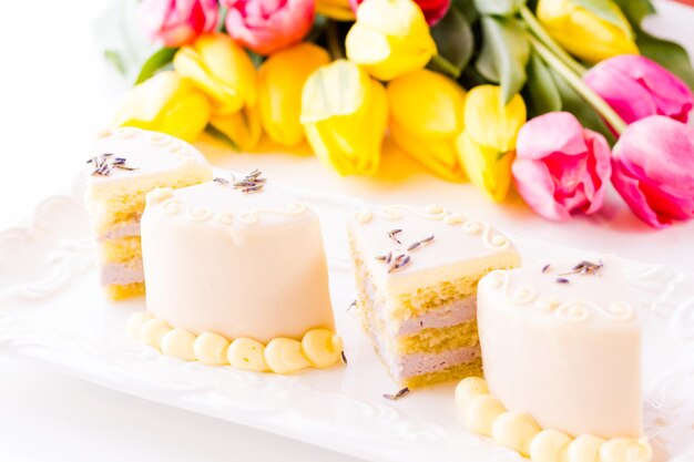 Weiße Schokoladen-Honig-Lavendel-Torte aus Biskuitkuchen mit Honig und gefüllt mit Lavendelmousse, umhüllt von weißer Schokolade.