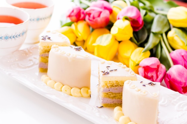 Weiße Schokoladen-Honig-Lavendel-Torte aus Biskuitkuchen mit Honig und gefüllt mit Lavendelmousse, umhüllt von weißer Schokolade.