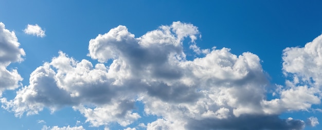 Weiße skurrile Wolke auf einem Hintergrund des blauen Himmels