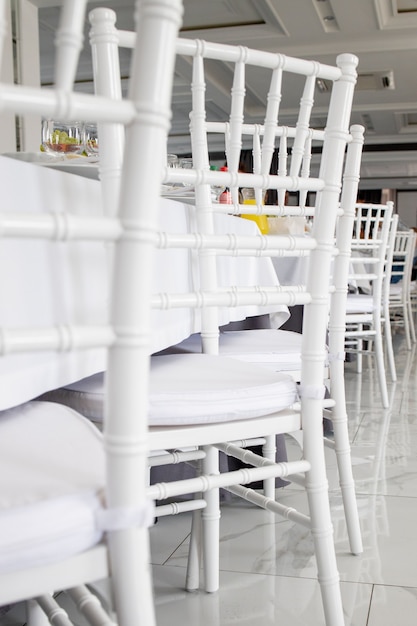 Weiße Stühle, weiße Tischdecken auf den Tischen im Restaurant.