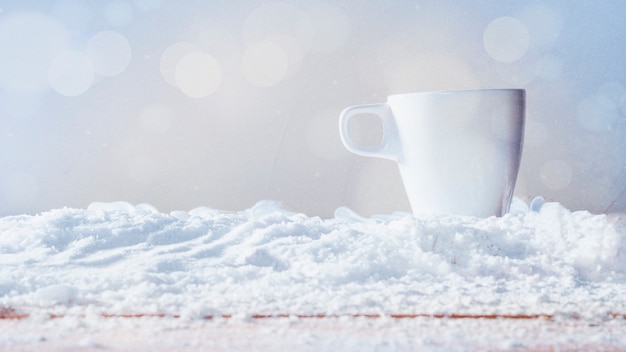 Weiße Tasse auf Schnee gelegt