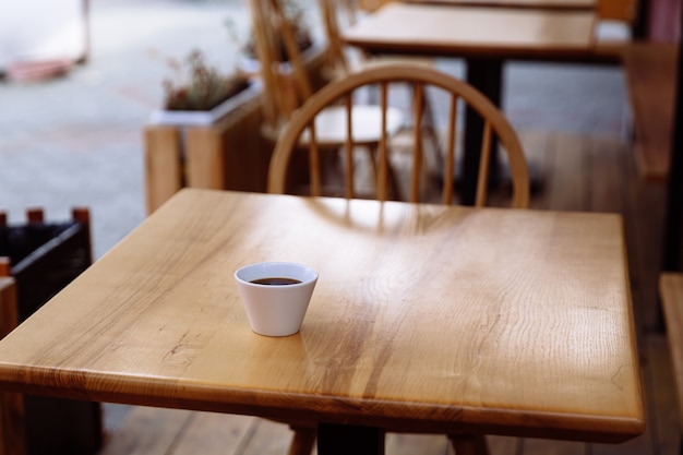 Weiße Tasse Kaffee auf einem Holztisch