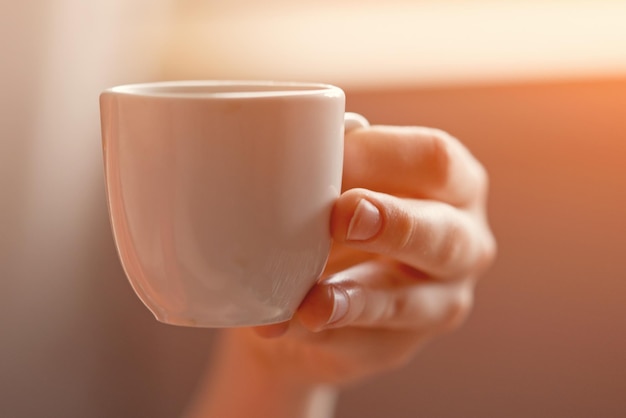 Weiße Tasse Kaffee in der Hand Getönt