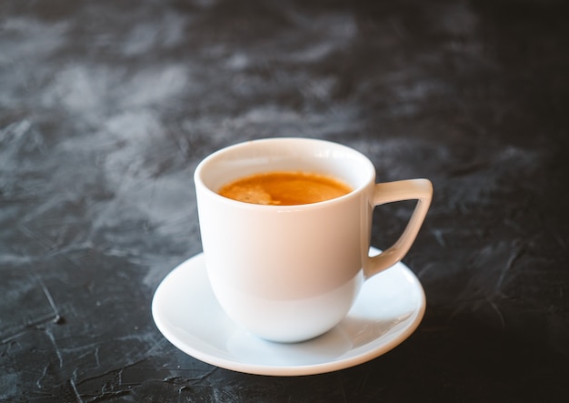 Weiße Tasse Latte-Kaffee auf einem schwarzen Schiefertisch