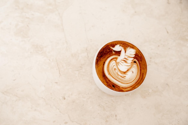 Weiße Tasse leckeren Cappuccino mit Latte Art auf weißem Marmorhintergrund im Café