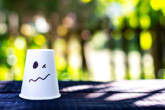 Foto weiße tasse mit gezeichneter emotion der überraschungsverwirrung