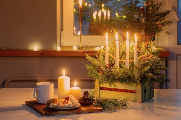 Weiße Tasse mit Heißgetränk und Weihnachtsschmuck zu Hause