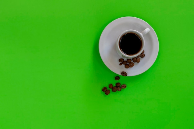 Weiße Tasse mit Kaffee auf der grünen Tafel.