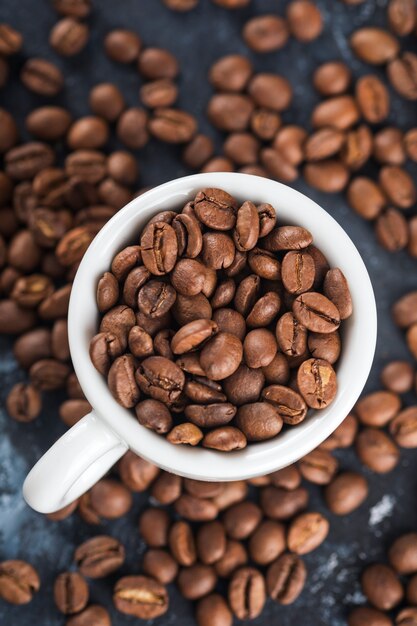 Weiße Tasse mit Kaffeebohnen. Makroansicht. Selektiver Fokus