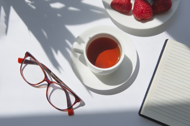 Weiße Tasse schwarzen Tees mit Palmenschatten