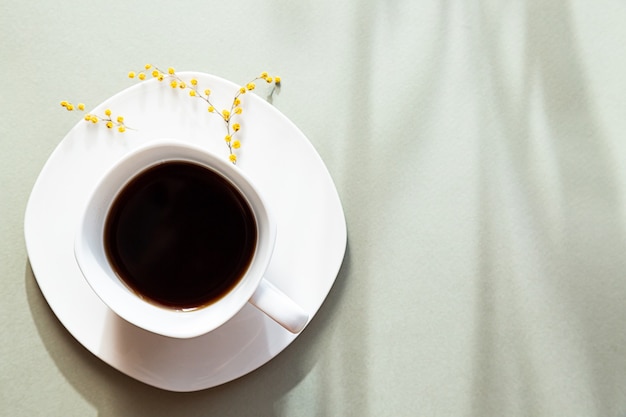 Weiße Tasse schwarzer Kaffee lange Schatten