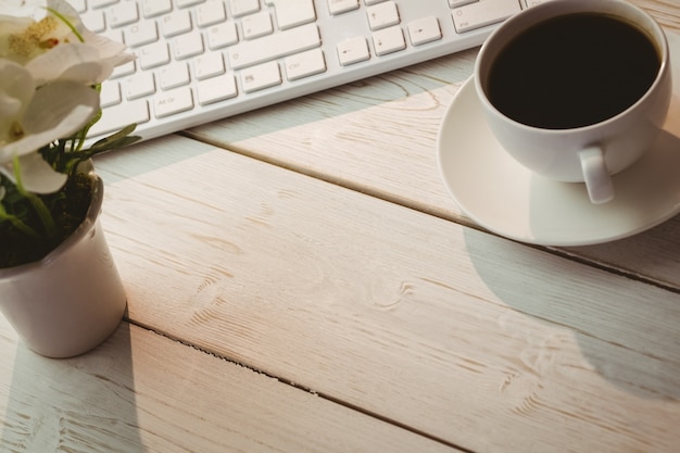 Weiße Tastatur und Tasse Kaffee