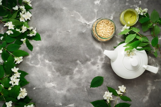 Weiße Teekanne, trockener Kräutertee, Jasminblüte, schwarzer weißer Marmor. Teezeit Draufsicht Vorlage langes Web-Banner