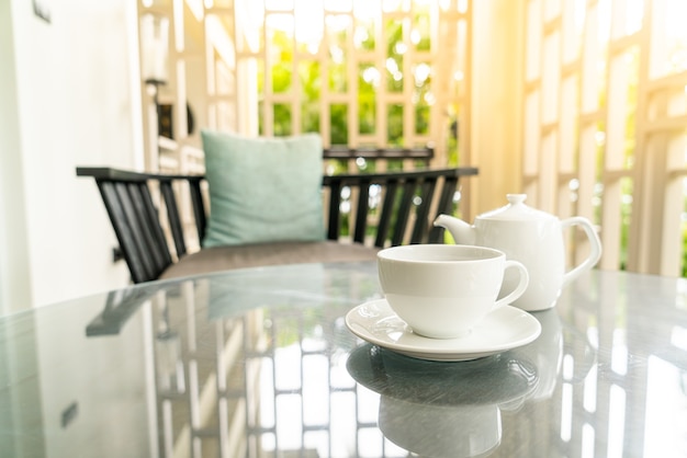 weiße Teetasse mit Teekanne auf dem Tisch