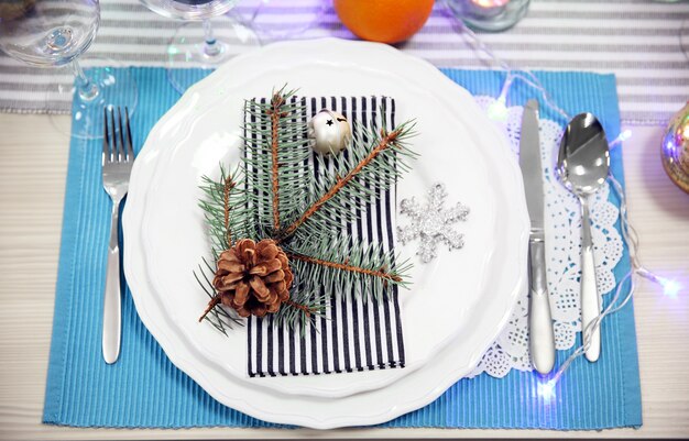 Weiße Teller mit Besteck auf einem Weihnachtstisch, Nahaufnahme