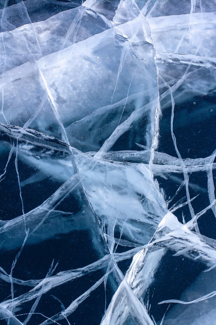 Weiße tiefe Risse im transparenten klaren Eis. See mit blauem Eis. Vertikal.