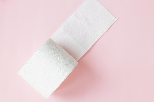 Weiße Toilettenpapierrolle auf dem hellrosa Hintergrund