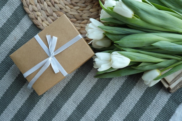 Weiße Tulpen Blumen und Geschenk oder Geschenkbox grüner Hintergrund Muttertag Geburtstag Valentinstag Frauentag Feier Konzept Platz für Text