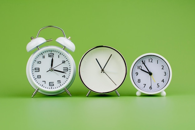 Weiße Uhr auf grünem Hintergrund Konzept der Zeit Zeit ist wichtig für die Arbeit