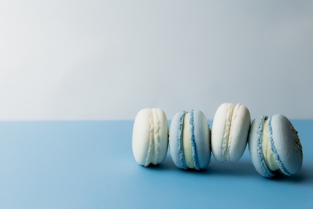 Weiße und blaue Makronen auf dem Tisch, Makronen auf blauem Hintergrund. Hochwertiges Foto