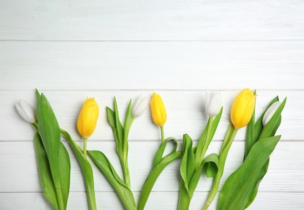 Weiße und gelbe Tulpen auf hölzernem Hintergrund