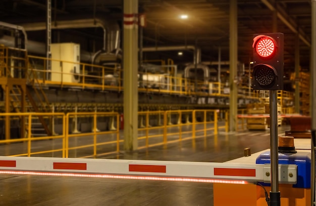 Weiße und rote Absperrgitter oder Absperrzäune und Symbolleuchten zur Kontrolle der Durchfahrt von Autos in der Fabrik aus Sicherheitsgründen