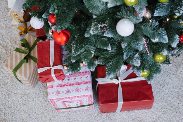 Weiße und rote Weihnachtsgeschenkboxen mit Bändern unter dem Weihnachtsbaum