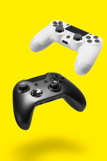 Foto weiße und schwarze gamecontroller an gelber wand