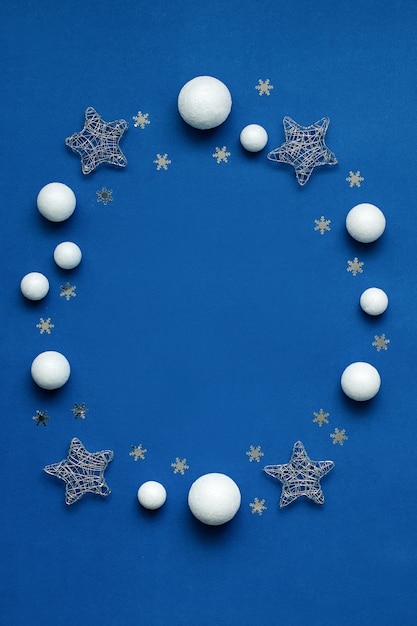 Weiße und silberne Dekorationen flach auf klassischem blauem Hintergrund mit Kopierraum. Weihnachtshintergrund in der Farbe klassisch blau mit weißen und silbernen Ornamenten, Weihnachtshintergrund mit Wunschliste