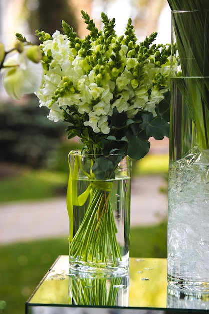 Weiße Vase mit Blumen in einem Restaurant Korb mit Blumen Kibana Hochzeitsfloristik