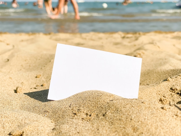 Weiße Visitenkarte liegt im Sand