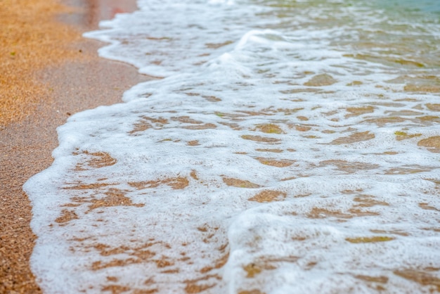 weiße Welle auf leerem gelbem sandigem Strandsommer oder tropischem Klimahintergrund Naturhintergrund