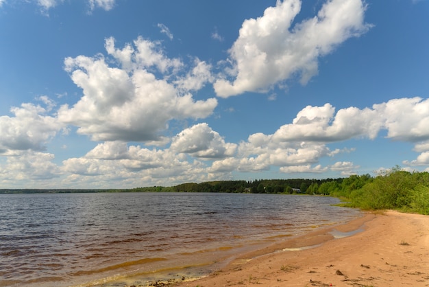 Weiße Wolken am blauen Himmel über dem Fluss. Sommer heller Tag im Urlaub.