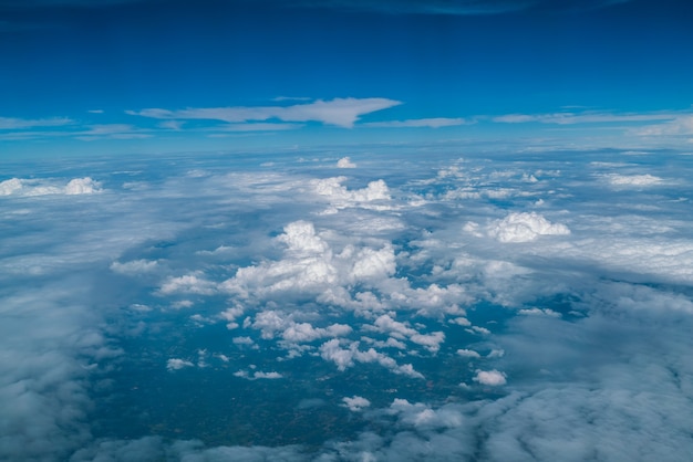 Weiße Wolken im blauen Himmel angesehen vom Flugzeugfenster.