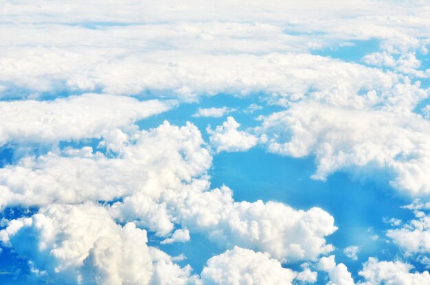 Weiße Wolken und blauer Himmel aus dem Flugzeugfenster.