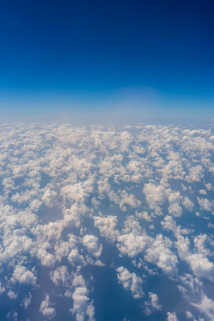 Weiße Wolken und blauer Himmel ein Blick aus dem Flugzeugfenster