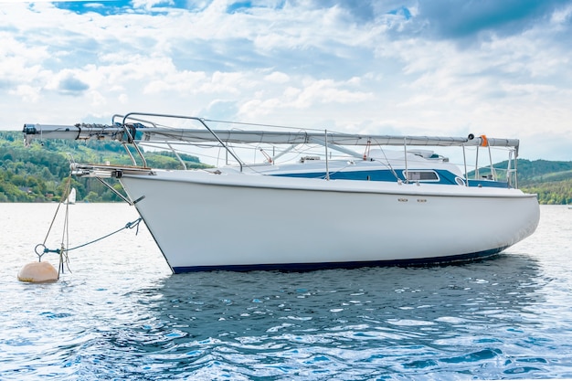 Weiße Yacht auf dem See mit blauem Himmel.