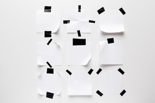 Weiße zerrissene Anmerkung, Notizbuchpapier fest mit dem schwarzen Klebeband lokalisiert auf weißem Hintergrund