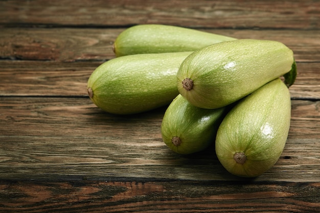 Weiße Zucchini auf einem hölzernen Hintergrund, Layout für eine gesunde Ernährung und organische Werbung des Restaurantkochens.