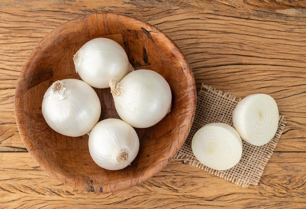 Weiße Zwiebeln in einer Schüssel über Holztisch