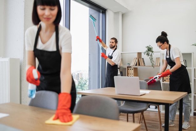 Foto weißer arbeiter in einer schwarzen schürze reinigt ein panoramablickfenster