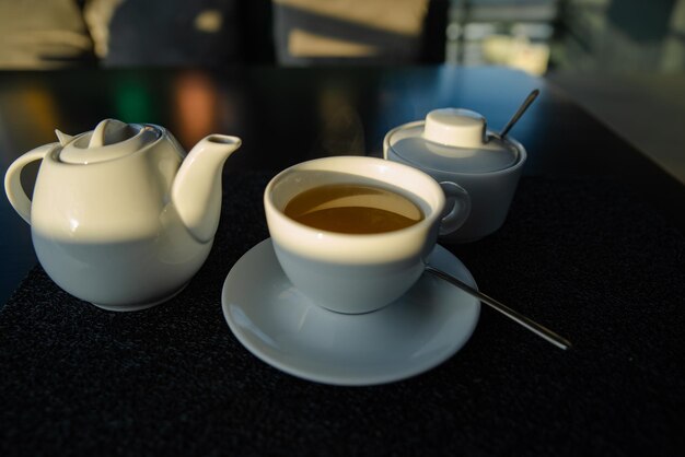 Foto weißer becher mit kessel auf dem kaffeetisch