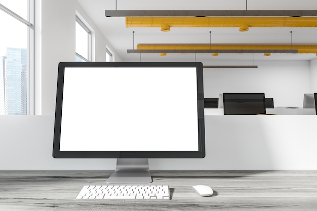 Weißer Computermonitor steht auf einem weißen Schreibtisch in einem modernen Büro. Eine Vorderansicht. 3D-Rendering-Attrappe