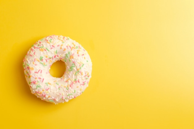 weißer Donut auf Draufsicht der gelben Wand